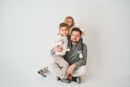 Happy family. Father, daughter and son hugging and smiling on white background. Paternity. Single father bring up his childrenの写真素材