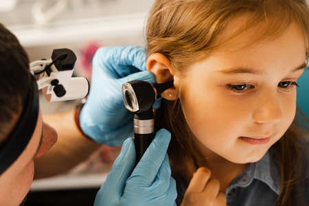 Close-up examination of childs ear with otoscope. Otoscopy. Visit to ENT doctor and consultationの写真素材
