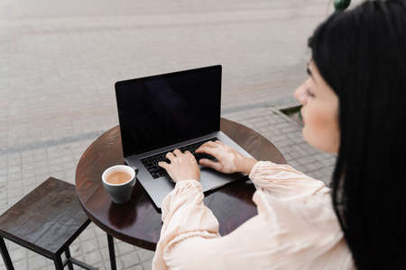 Woman typing text on laptop. Hands with vitiligo pigmentation seasonal skin disease. Working online. Lifestyle with vitiligoの写真素材