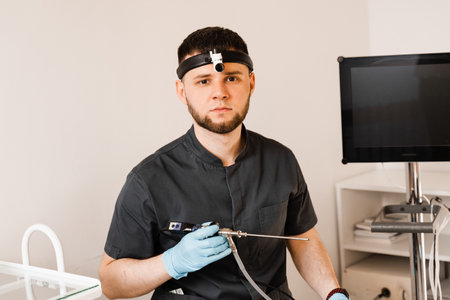 ENT doctor otolaryngologist with endoscope in hands. Prepearing for endoscopy procedure. Doctor with...