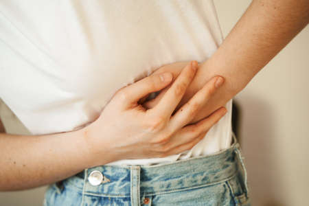 Stomach pain. Pancreatitis disease of pancreas becomes inflamed. Sick girl hold abdomen because it hurtsの写真素材