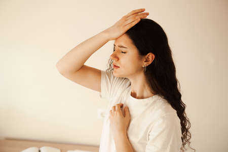 Sad woman with migraine strong headache disease. Depression. Overstressed woman with head pain touches headの写真素材