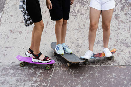 Kids friends with skateboard and penny boards on skate board park. Extreme lifestyle. Active...