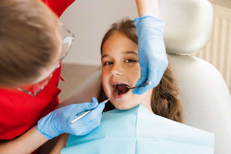 Cheerful child girl smiling at dentists consultation in dentistry. Dental diseases. Consultation with pediatric dentist for treatment of toothache in childの写真素材
