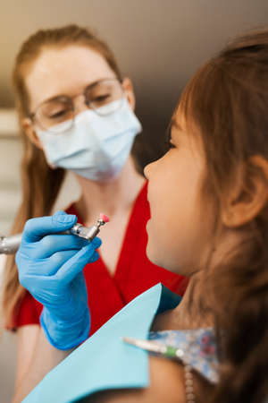 Child dentist makes professional teeth cleaning close-up in dentistry. Professional hygiene for...