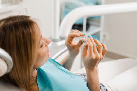 Clear aligner for bite correction and shape of teeth. Orthodontist shows transparent removable...