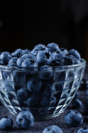 Blueberries natural organic berry with water drops on black background. Blueberry in glass bowl plateの写真素材