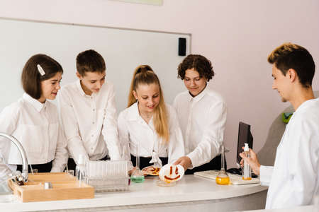 Education. Chemical experiments at a chemistry lesson at school. Children classmates making...