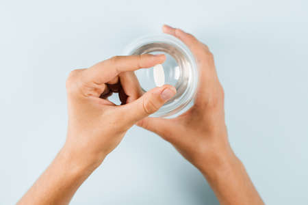 Holding weight loss pill for diet and ready to drink water close-up. Diet with biologically active...