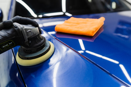 Car polishing with orbital polisher for remove scratches. Worker of detailing auto service making final polishing for carの写真素材