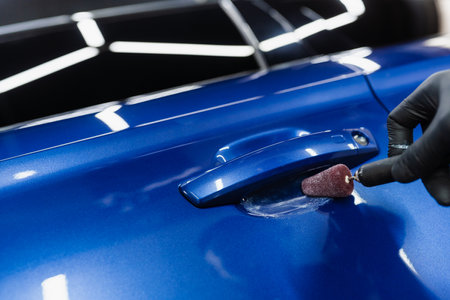 Car handle polishing with orbital polisher for remove scratches under handles of car. Worker of detailing auto service making final polishing for carの写真素材