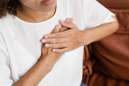 Heart attack disease of african american woman. Symptoms of angina pectoris. Attractive sick black girl with heart ilness infarktの写真素材