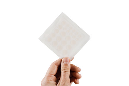 Top view of acne patch for facial rejuvenation. Set of round patches for acne in hand on white...