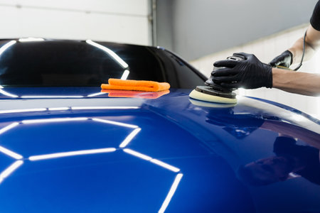 Hard wax car polishing with orbital polisher for remove scratches close-up. Working process in...