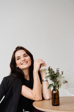 Satisfied successful girl enjoying her lifestyle and dreaming in white office at break. Young...