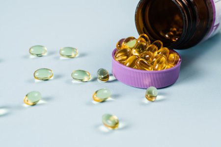 BADS Capsules of Omega-3 biologically active dietary supplements in plastic jar close-up. Vitamin D...