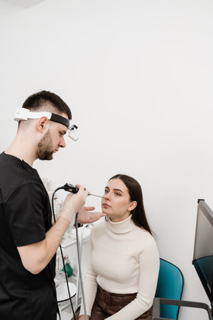 Nose endoscopy. Rhinoscopy procedure with rhinoscope. ENT doctor otolaryngologist with headlight...