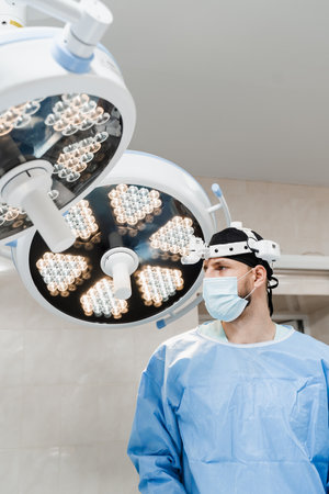Portrait of male surgeon with headlight in the operating room before surgery. Concept of health care...