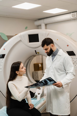 CT Doctor consulting patient and showing chest x-ray to patient in computed tomography room. CT scan...
