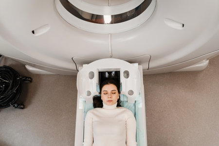 CT scan of brains of girl in medical clinic. Woman is doing computed tomography x-ray examination of tumor in head in CT scan roomの写真素材