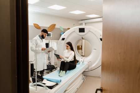 CT Doctor consulting patient and showing brains x-ray to patient in computed tomography room. CT scan radiologist showing x-ray of brains to girl patient in computed scanning roomの写真素材
