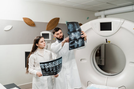 Two doctors discussing x-rays after CT scan of patient abdomen. CT Computed tomography scan...