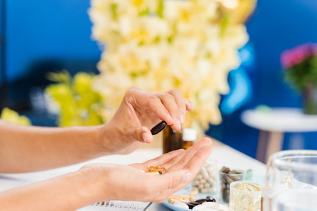 Nutritionist is holding different dietary supplement pills in her hands and writing prescription for...