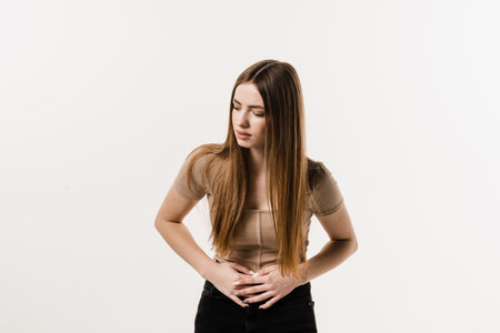 Sick attractive girl hold abdomen because it hurts. Stomach pain. Pancreatitis disease of pancreas becomes inflamedの写真素材