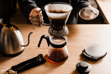 Clever coffee dripper with pour over filter and accessories on the wooden table in cafe. Drip filter coffee brewing. Clever coffee dripper alternative method of brewing filter coffee at homeの写真素材