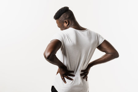 African american man feel backache spine pain because of UTI pyelonephritis disease on white background. Kidney infection pyelonephritis urinary tract infectionの写真素材