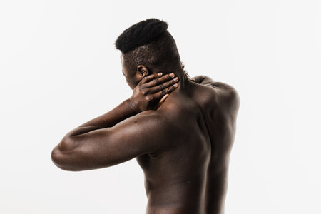 Scoliosis is sideways curvature of the spine of muscular african american man. Rheumatism and arthritis diseases. Rachiocampsis bachache and neck pain of shirtless african man on white backgroundの写真素材