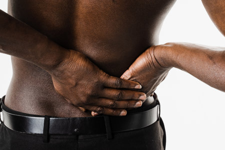 PID infection of one or more of the upper reproductive organs, including the uterus, fallopian tubes and ovaries. Muscular african american man with pelvic inflammatory disease on white backgroundの写真素材