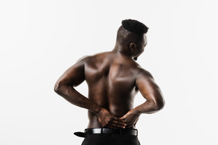 Muscular african american man with pelvic inflammatory disease on white background. PID infection of one or more of the upper reproductive organs, including the uterus, fallopian tubes and ovariesの写真素材