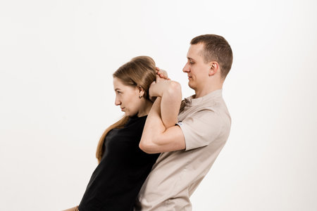 Orthopedist examining female neck and head. Manual correction of the ridge and cervical region. Rehabilitation therapy on white background. Manual therapy at physiotherapist or chiropractorの写真素材