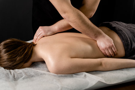 Classic massage close-up. Therapeutic massage with manipulating body to promote relaxation and reduce stress. Massage therapist use techniques such as friction, stretching, and tappingの写真素材
