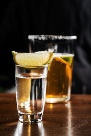Shot of tequila with lime and beer ingredients of alcoholic cocktail Death of Mexican at the bar. Classic cocktail Death of Mexican on black backgroundの写真素材