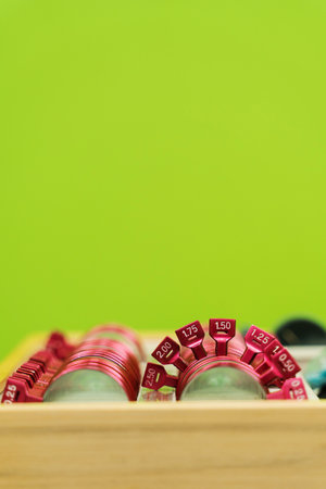 Close-up set of lenses for trial frame glasses on green background. Ophthalmology equipment to examine eye visual system of patient with short or long power visionの写真素材