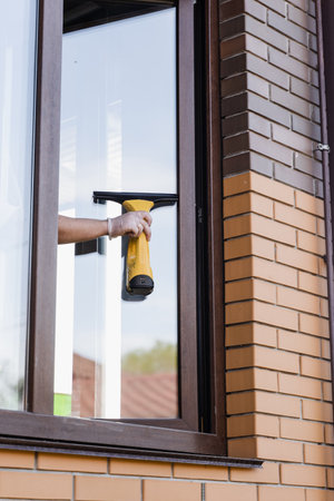 Process of window washing outside to remove dust, dirt and water. Cleaning window using portable vacuum windows cleanerの写真素材