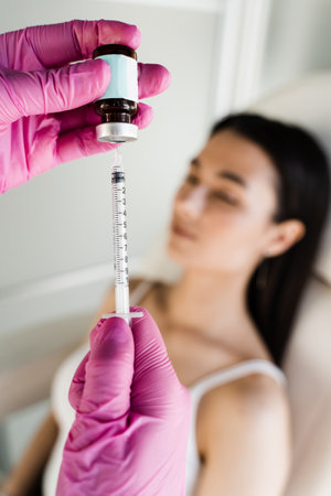 Cosmetologist before injecting facial biorevitalization for moisturizing effect. Facial biorevitalization for increasing skin tone, reducing wrinkles, and strengthening oval of the faceの写真素材