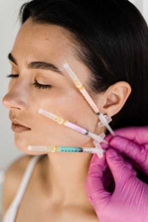 Girl with vitamin cocktail syringes for injections. Mesotherapy injections of vitamins, enzymes,...
