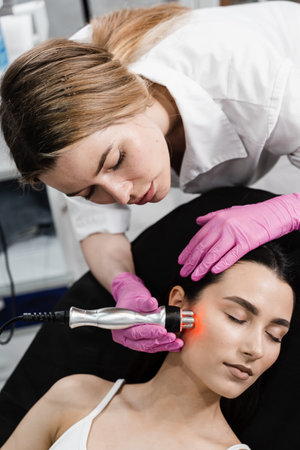 Red light of thermal or radio frequency on face of young woman for hardware RF lifting. Tightening...