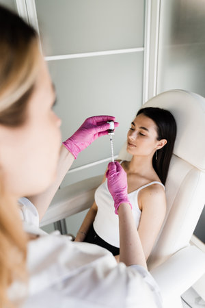 Cosmetologist before mesotherapy injections in neckline of girl. Mesotherapy injections of vitamins, enzymes, hormones, and plant extracts to rejuvenate and tighten skin, as well as remove excess fatの写真素材