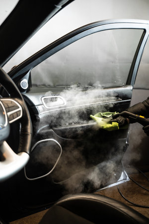 Cleaning and disinfecting by steam cleaner of the leather car interior. Removing stains and disinfecting car doorの写真素材