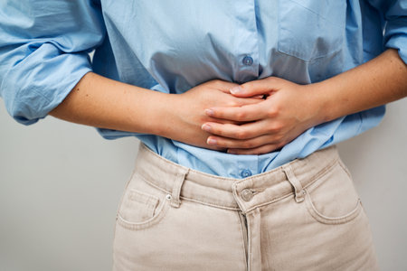 Woman Holds Her Aching Belly With Both Hands. Suffering From Stomach Pain