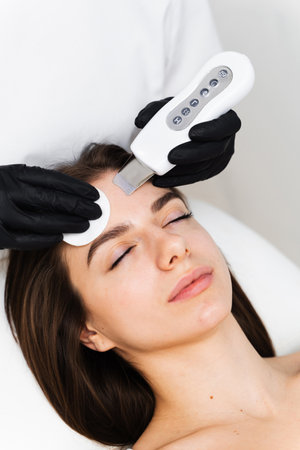 Process of applying cavitation peeling hardware. Cleansing facial skin with help of ultrasound...