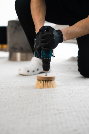 Cleaning the carpet at home using drill and brush. Easy removal of stains on carpet with drill and brush. Smearing detergent deep into fibers to clean carpet with drill and brushの写真素材