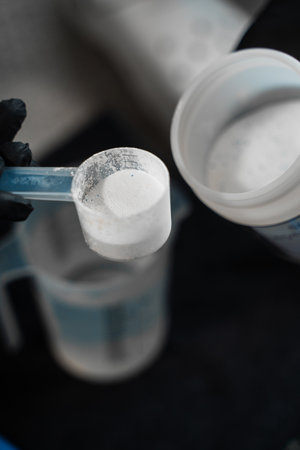Measuring the ratio of oxygen bleach and water for cleaning furniture. Pouring dry cleaning powder...