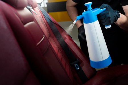 Process of splashing disinfector on car seatback. Detailing auto seats using special spray of detergentの写真素材