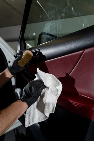 Disinfection car door panel. Removing dust and dirt from leather auto car panel using microfiber rag and detergent. Detailing procedureの写真素材