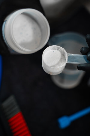 Pouring dry cleaning powder into water. Measuring the ratio of oxygen bleach and water for cleaning...